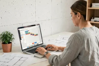 Femme utilisant un logiciel de planning travaux en ligne pour générer un PDF de rénovation sur son ordinateur portable